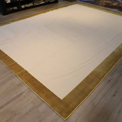 A Cream Area Rug Brown Border And Carved Pattern